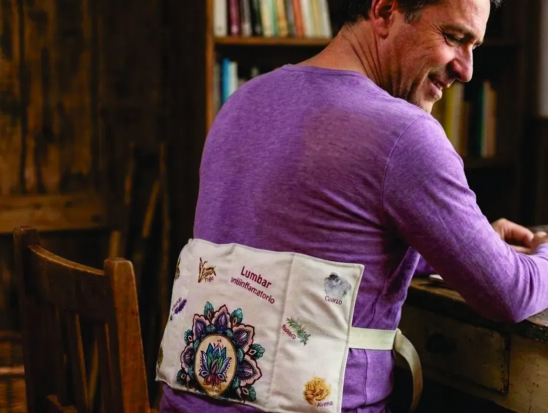 Hombre usando un cojín de semillas lumbar amarrado a la cintura mientras trabaja
